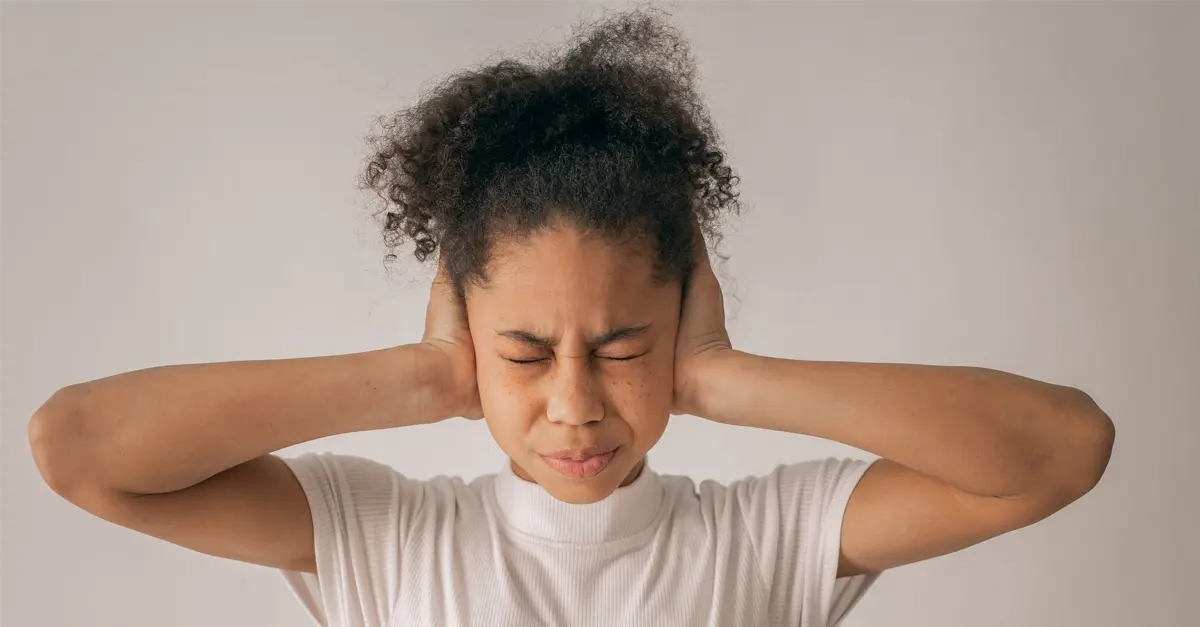 kid stimming while holding ears